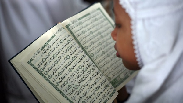 A muslim woman reads and studies the Quran