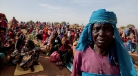 A Sudanese refugee who is seeking refuge in Chad waits with other refugees