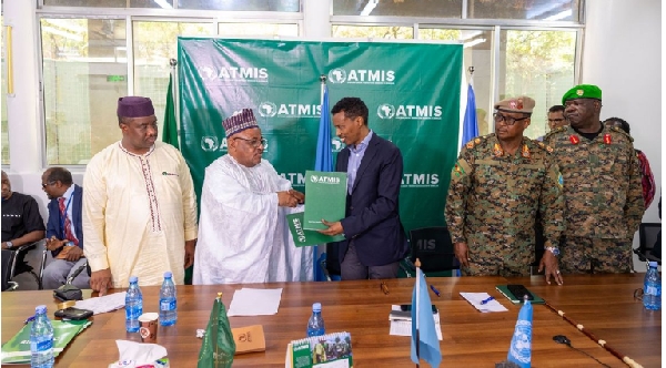ATMIS Head (L) hands over a signed document to Somalia’s National Security Adviser Hussein Sheikh