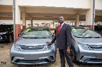 Dr Yaw Adutwum standing by some of the cars