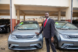 Dr Yaw Adutwum standing by some of the cars