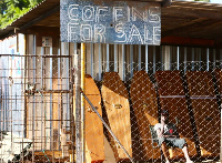 A worker at a coffin-making company waits for clients in Harare, Zimbabwe