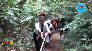 Adventurers holding a thick rope to climb up to the cave