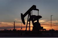 A drone view of a pump jack and drilling rig south of Midland, Texas, U.S.
