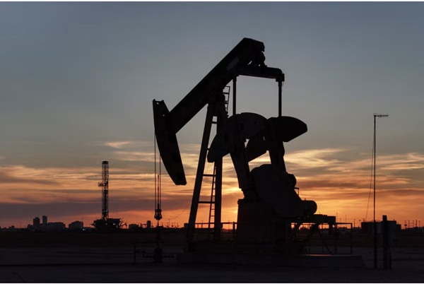 A drone view of a pump jack and drilling rig south of Midland, Texas, U.S.