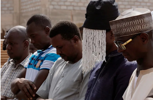 Undercover journalist Anas Aremeyaw Anas prays with others for his slain colleague Ahmed Suale