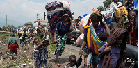 People carry their belongings as they flee from their villages around Sake in Masisi territory
