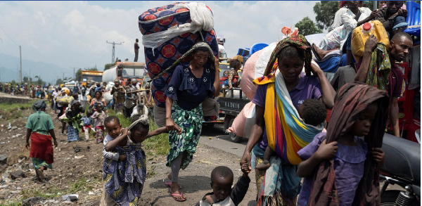 People carry their belongings as they flee from their villages around Sake in Masisi territory