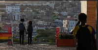 Two schoolgirls hold hands as they look towards the city in Praia, Cape Verde, Thursday, May 7, 2026