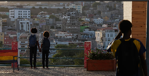 Two schoolgirls hold hands as they look towards the city in Praia, Cape Verde, Thursday, May 7, 2026