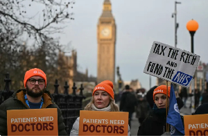 Staff members hold placards as they stand on a picket line during the first day of a five-day strike