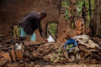Deogratias Kasereka, chief of Mukondi village, searches the remains of a house