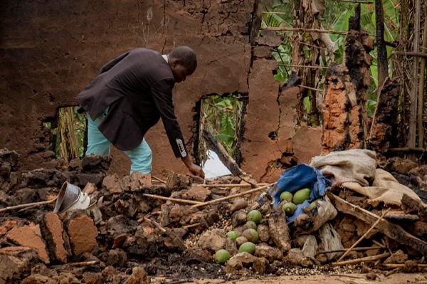 Deogratias Kasereka, chief of Mukondi village, searches the remains of a house