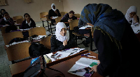 Schoolchildren listen to their teacher in class