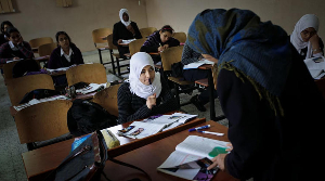 Schoolchildren listen to their teacher in class