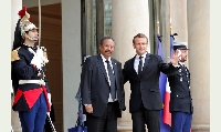 French President Emmanuel Macron (R) welcomes Sudan's Prime Minister Abdalla Hamdok