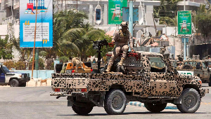 Somali security officer holds position on their open truck near Syl Hotel