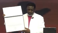 Archbishop Agyinasare showing the certificate of the lifetime award to his congregation