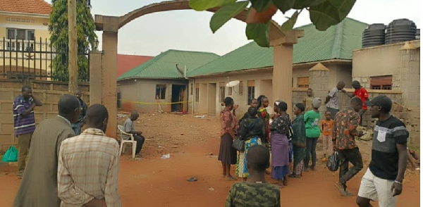 Residents and passersby look on at the rented house where three siblings died in a fire