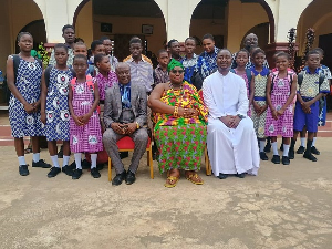 Nana Amoafoa II in a group picture with some pupils of her community