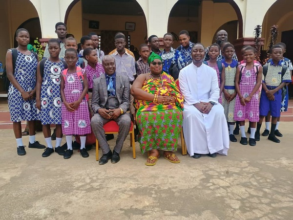 Nana Amoafoa II in a group picture with some pupils of her community