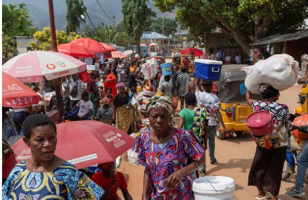 Congolese civilians walk at Maendeleo market as calm returns after clashes between AFC and M23