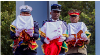 A military guard of honour raised swords as three men in traditional dress carried the skulls