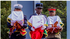 A military guard of honour raised swords as three men in traditional dress carried the skulls