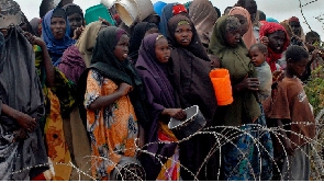 Internally-displaced Somalis wait for food at a distribution point  at a refugee camp