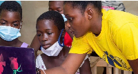 Adelaide teaching basic computer skills to girls in her community