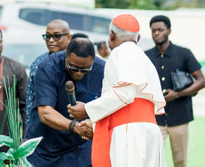 Elvis Afriyie Ankrah bows to shake hands with Cardinal Appiah Turkson