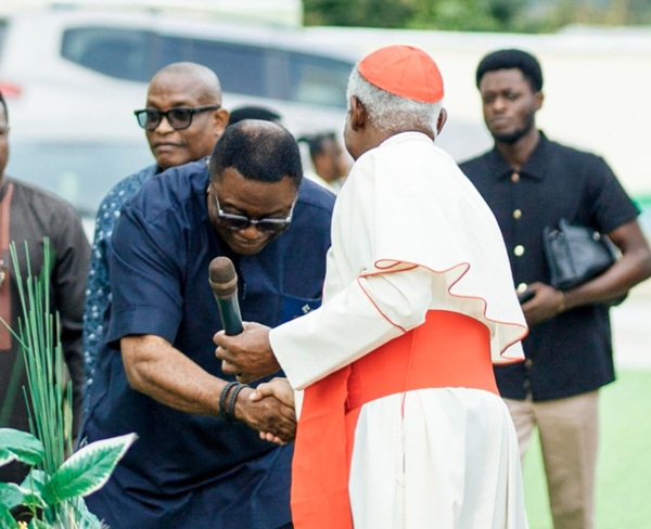 Elvis Afriyie Ankrah bows to shake hands with Cardinal Appiah Turkson