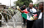 Families lay flowers on barbed wire barricade on anniversary of deadly Kenya protests