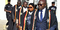 Uganda's EC commissioners, led by chairman Simon Byabakama, walk after announing initial results