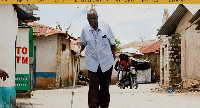 Alfred Ogulo Mulo, a village elder, walks along a street in Mikindani, Mombasa County, Kenya
