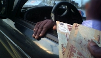 A photo showing someone offering money as bribe