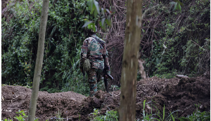 A member of the M23 rebel group walks on the outskirts of Matanda