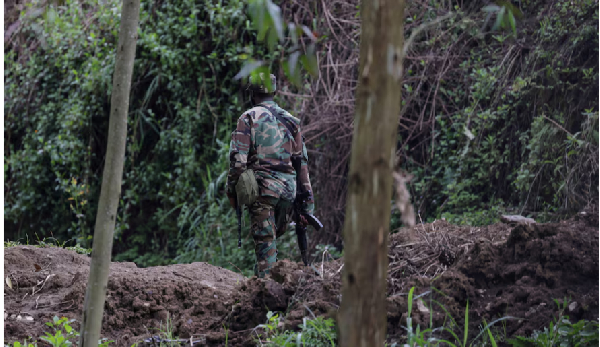 A member of the M23 rebel group walks on the outskirts of Matanda