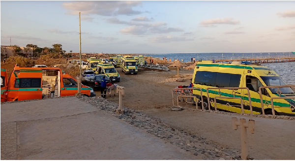 Rescuers and ambulance cars wait on the beach for possible survivors