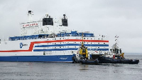 A small motorboat passes anchored vessels in the Strait of Hormuz off Bandar Abbas