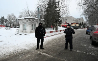 Security officers stand guard outside an army base where a building collapsed in Sertolovo in Russia