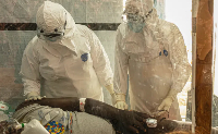 Health workers treat an Ebola patient