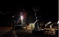 Young men fix a tyre in the dark at an all-night truck stop in Insuza