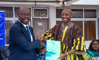Finance Minister Dr Cassiel Ato Forson presentig files to Dr Alhassan Iddrisu