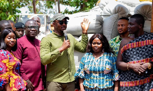 Malik Basintale [M] CEO of the Youth Employment Agency (YEA) presenting the bags of maize