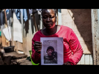 A mother holds a photo of her son, David Shitanda, in Kibera