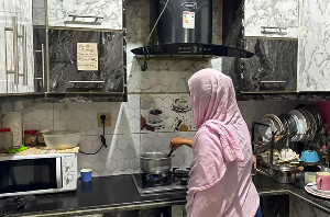 Farhat Qureshi cooking at her house in Karachi, Pakistan