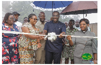 Samuel Awuku cutting a ribbon with guests