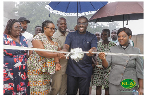 Samuel Awuku cutting a ribbon with guests