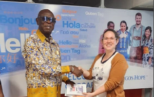 Daniel Owusu-Koranteng (left) presenting the books to a member of the Logos Hope